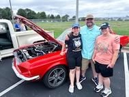 JOINT BASE ANACOSTIA-BOLLING, Washington, D.C. (July 30, 2024) - Dr. Greg Bouton (center) and his two daughters pose for a picture with their 1968 Ford Mustang during Strategic Systems Programs' (SSP) annual command picnic, Tuesday. Bouton and his daughters have teamed together for months to build and restore the Mustang. This year's event for SSP staff and their families included food, games, a dunk tank, and the car show which featured vehicles--old and new--owned by members of the SSP workforce. The picnic was organized by SSP’s Activity and Recreations Committee (SPARC), an all-volunteer team made up of military and civilians who fundraise and plan MWR events throughout the year. SSP is the Navy command that provides cradle-to-grave lifecycle support for the sea-based leg of the nation’s nuclear triad. (U.S. Navy Photo by Lt. Jennifer Bowman/Released)