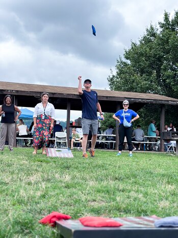 JOINT BASE ANACOSTIA-BOLLING, Washington, D.C. (July 30, 2024) - Strategic Systems Programs (SSP) Director Vice Adm. Johnny Wolfe Jr. throws a beanbag during a friendly competition of cornhole during the command's annual picnic, Tuesday. This year's event for SSP staff and their families included food, games, a dunk tank, and the car show which featured vehicles--old and new--owned by members of the SSP workforce. The picnic was organized by SSP’s Activity and Recreations Committee (SPARC), an all-volunteer team made up of military and civilians who fundraise and plan MWR events throughout the year. SSP is the Navy command that provides cradle-to-grave lifecycle support for the sea-based leg of the nation’s nuclear triad. (U.S. Navy Photo by Lt. Jennifer Bowman/Released)