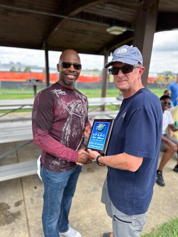 JOINT BASE ANACOSTIA-BOLLING, Washington, D.C. (July 30, 2024) - Strategic Systems Programs (SSP) Director Vice Adm. Johnny Wolfe Jr. (right) awards Ramon Kidd (left) 'Best in Show-Motorcycle' after votes were tallied  during the command's annual picnic Tuesday. This year's event for SSP staff and their families included food, games, a dunk tank, and the car show which featured vehicles--old and new--owned by members of the SSP workforce. The picnic was organized by SSP’s Activity and Recreations Committee (SPARC), an all-volunteer team made up of military and civilians who fundraise and plan MWR events throughout the year. SSP is the Navy command that provides cradle-to-grave lifecycle support for the sea-based leg of the nation’s nuclear triad. (U.S. Navy Photo by Lt. Jennifer Bowman/Released)