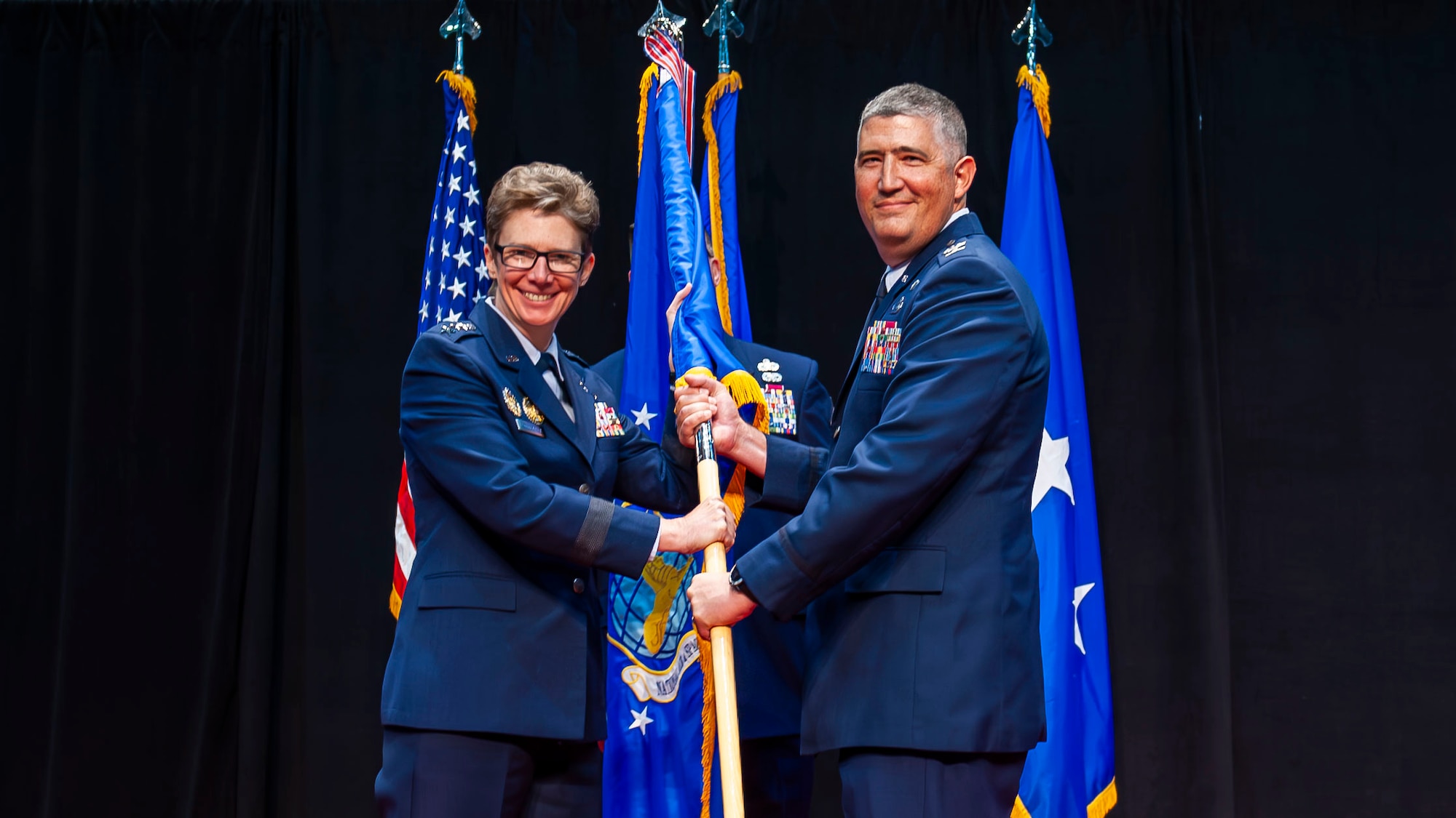 Lt. Gen. Lauderback and Col. Stremmel posing for a picture while holding the NASIC guidon