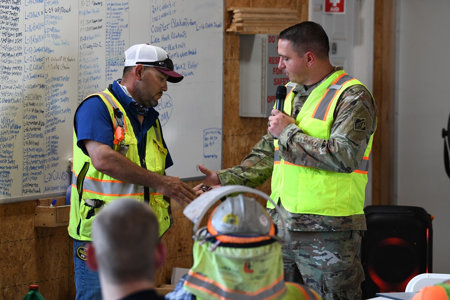 U.S. Army Corps of Engineers Nashville District Commander Lt. Col. Robert Green (right) presents his commander’s coin to Sergio Quintanilla, a carpenter superintendent from Thalle Construction, for his commitment to safety practices at a ceremony at Kentucky Lock, in Grand Rivers, Kentucky, July 30, 2024. The ceremony celebrated reaching one-million man-hours of work on the Kentucky Lock without a lost time incident. (USACE Photo by Michael Davis)