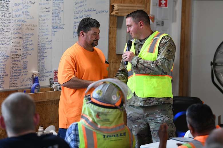 U.S. Army Corps of Engineers Nashville District Commander Lt. Col. Robert Green (right) presents his commander’s coin to Mark Rampage, a signalman and spotter from Thalle Construction, for his commitment to safety practices at a ceremony at Kentucky Lock, in Grand Rivers, Kentucky, July 30, 2024. The ceremony celebrated reaching one-million man-hours of work on the Kentucky Lock without a lost time incident. (USACE Photo by Michael Davis)