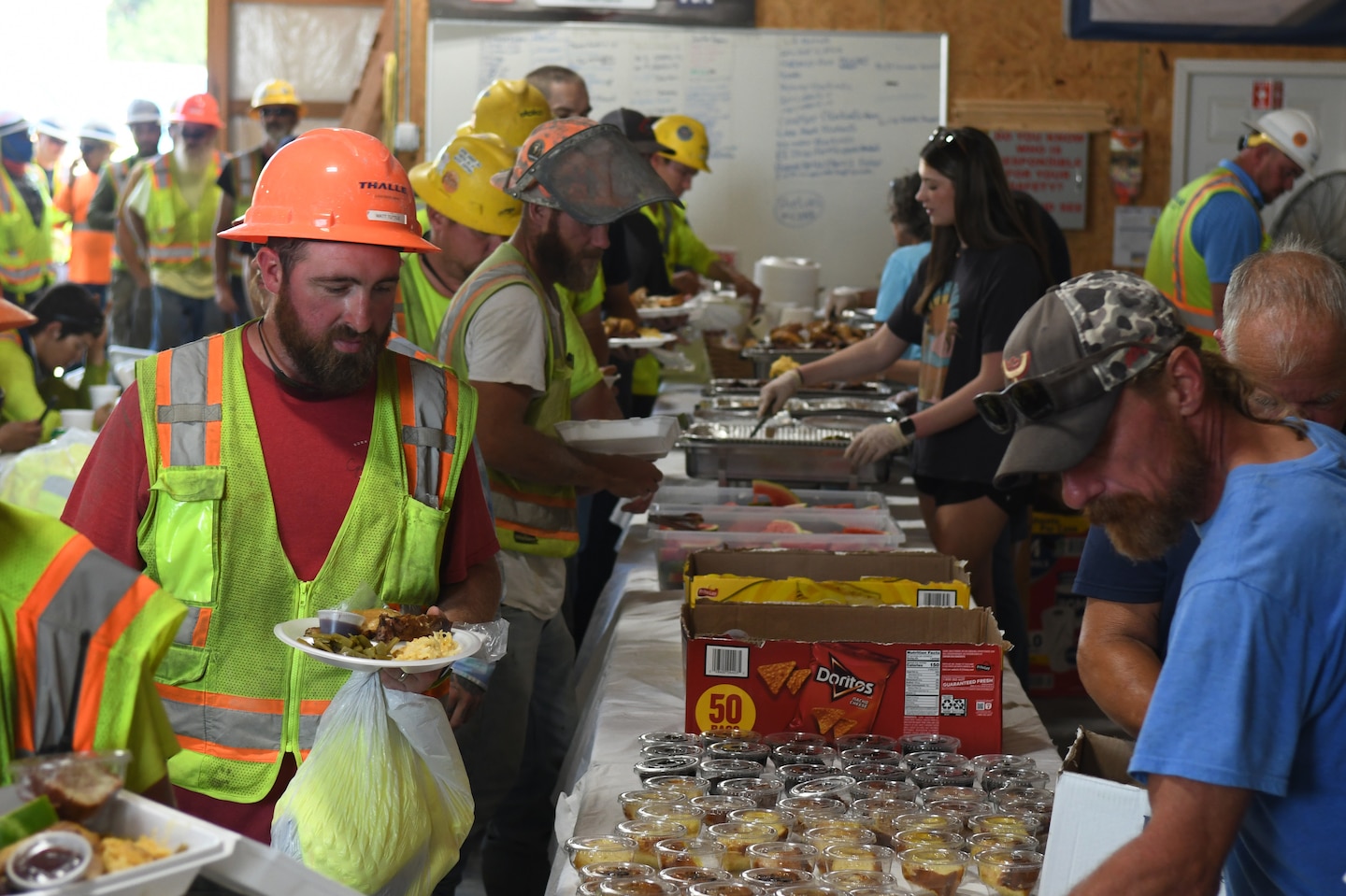 Construction workers from Thalle Construction, line up for food during a ceremony at Kentucky Lock, in Grand Rivers, Kentucky, July 30, 2024. The ceremony celebrated reaching one-million man-hours of work on the Kentucky Lock without a lost time incident. (USACE Photo by Michael Davis)