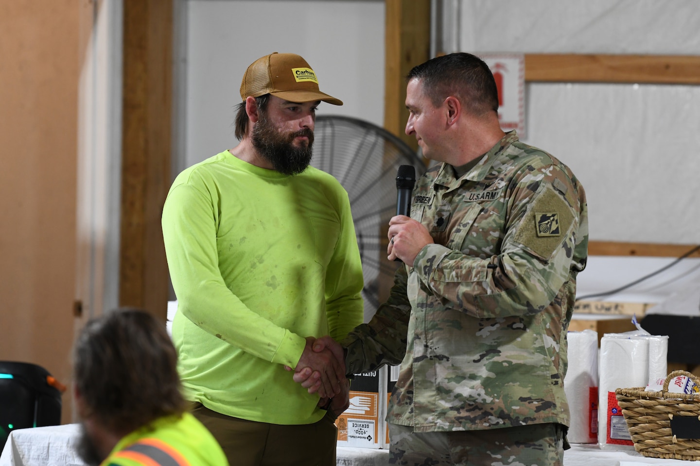 U.S. Army Corps of Engineers Nashville District Commander Lt. Col. Robert Green (right) presents his commander’s coin to Kyle Smith, a carpenter foreman from Thalle Construction, for his commitment to safety practices at a ceremony at Kentucky Lock, in Grand Rivers, Kentucky, July 30, 2024. The ceremony celebrated reaching one-million man-hours of work on the Kentucky Lock without a lost time incident. (USACE Photo by Michael Davis)