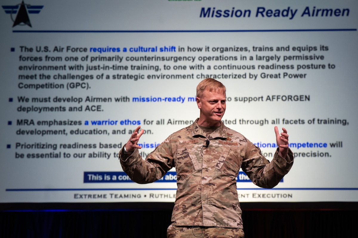 Man in USAF uniform talks on a stage.