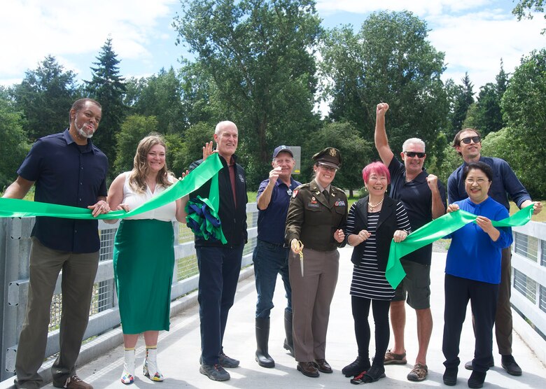 A group of people celebrating after a ribbon cutting ceremony.