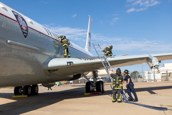 Firemen with ladder on aircraft