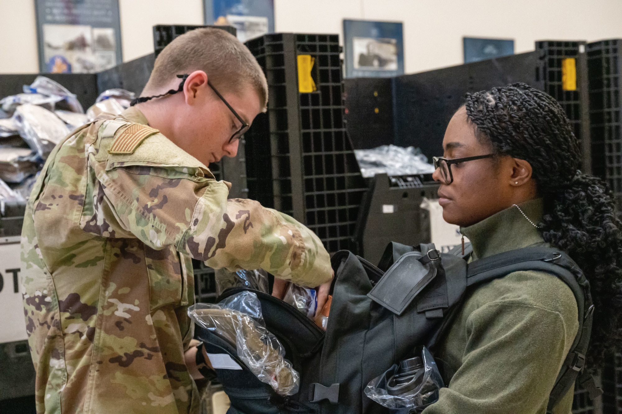 An incoming trainee receives a backpack and supplies for her seven-and-a-half weeks of Basic Military Training on April 23, 2024. Every Tuesday, new recruits are bussed in from the San Antonio International Airport to Joint Base San Antonio-Lackland, Texas, to begin seven-and-a-half weeks of Basic Military Training. The PRC represents the start of their transformation from civilians into Airmen. (U.S. Air Force by Ava Leone)