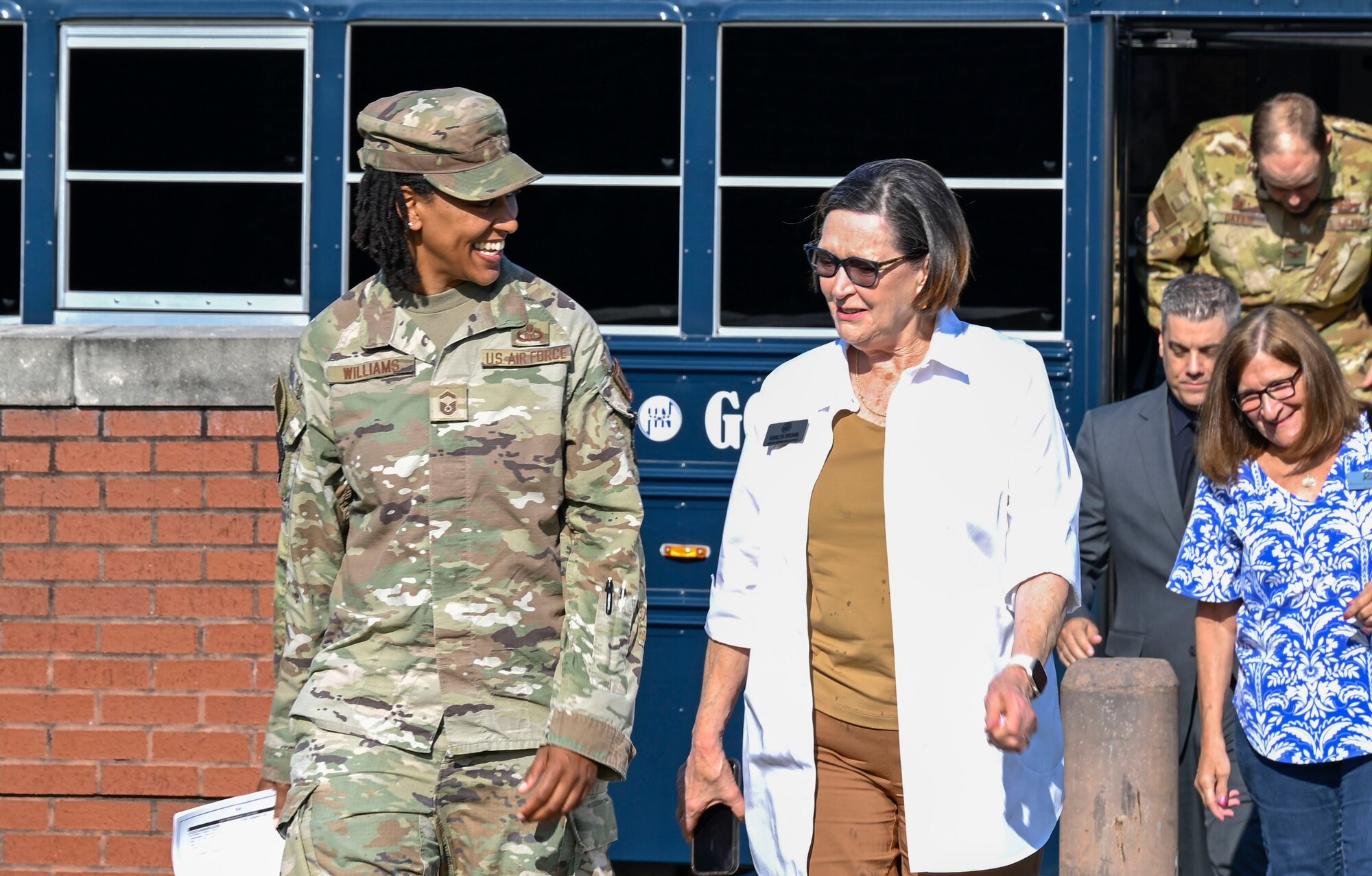 Two women walk and talk with each other.