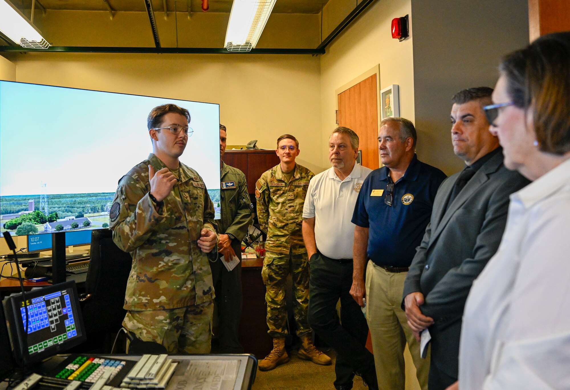 A man in uniform speaks to a group of people.