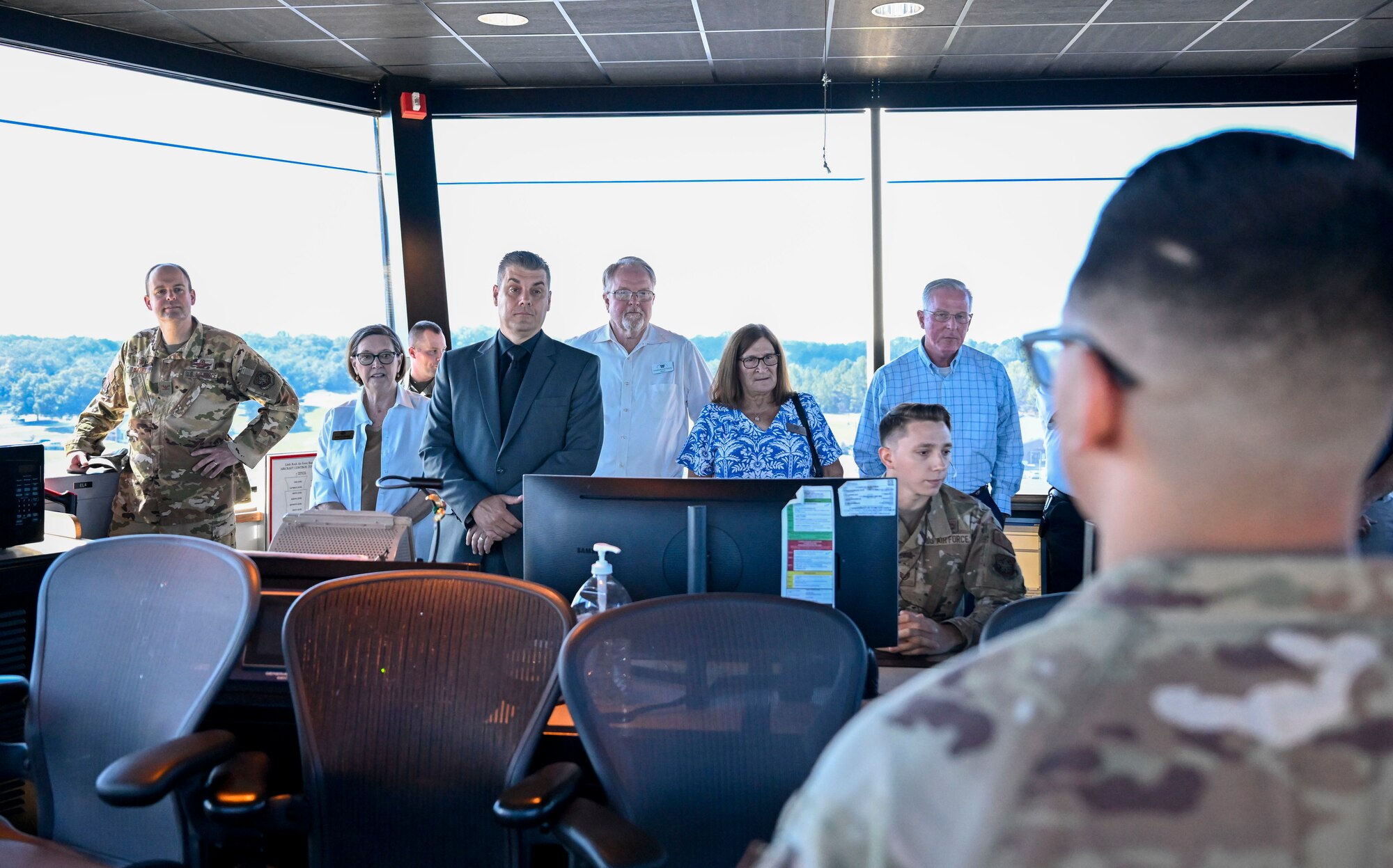 A group of people stand and listen to a briefing.