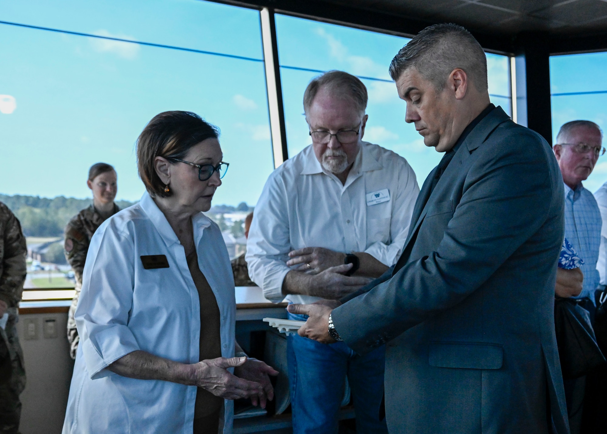 A group of people tours the inside of a control tower.