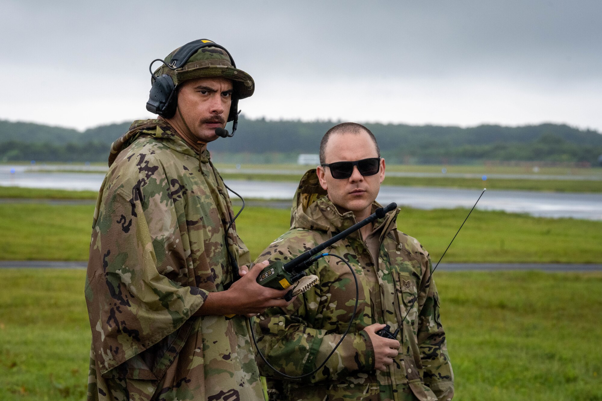 U.S. Air Force Tech. Sgts. Nelson Guerra, 36th Operations Support Squadron Landing Zone Safety Officer (LZSO) course participant, left, and Markanthony Diaz Jr., 374th Operations Support Squadron lead landing zone instructor, use radios to communicate with a C-130 Hercules during the first ever LZSO course at Misawa Air Base, Japan, July 26, 2024.