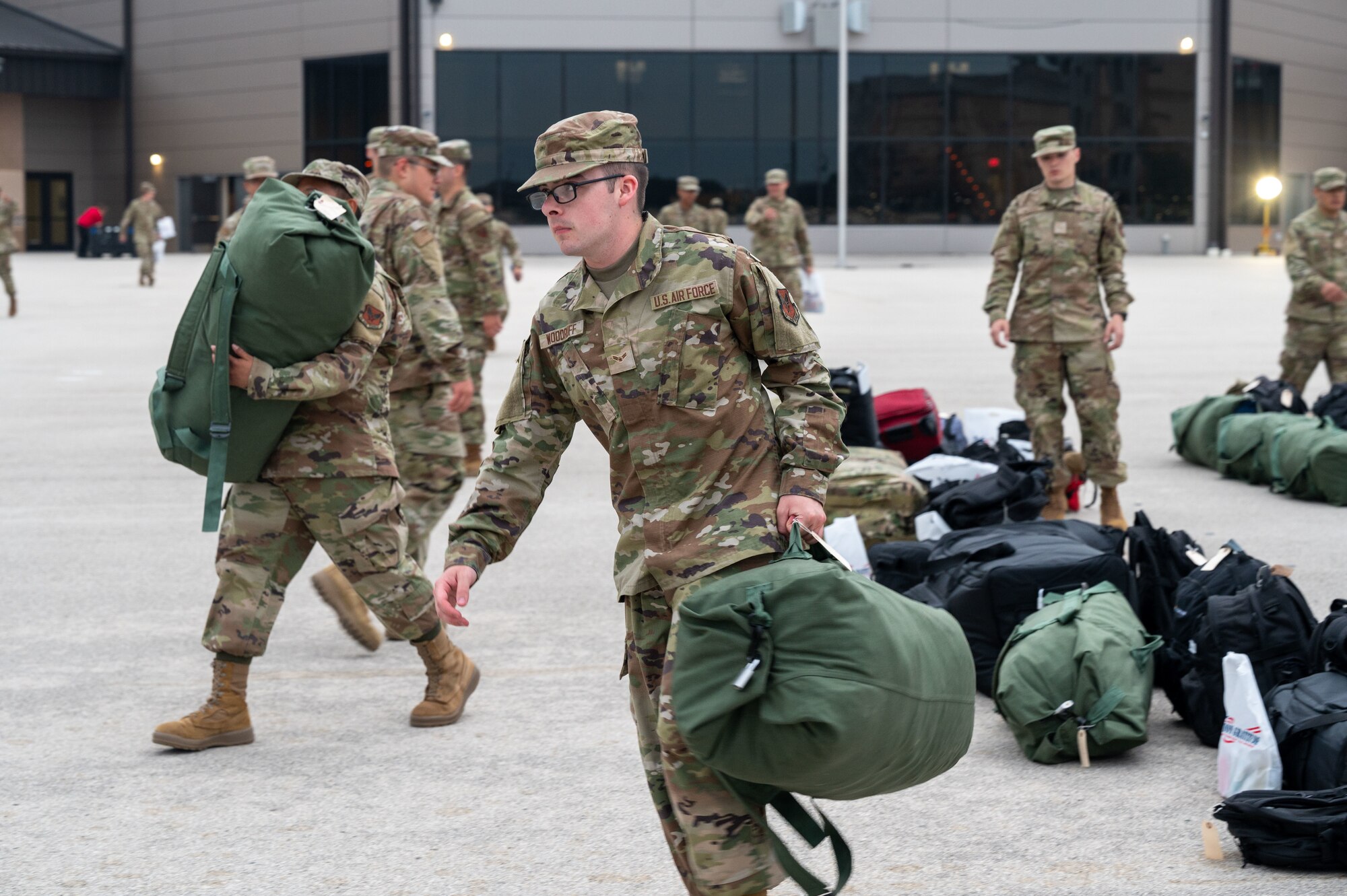An Airman carries his duffel bag towards a bus that will take him to his technical training school location on April 19, 2024. Each Friday morning, Airmen who graduated from Basic Military Training the day before, arrive at the Pfingston Reception Center to depart to their technical training schools where they will learn how to thrive in their specific jobs.  (U.S. Air Force by Ava Leone)