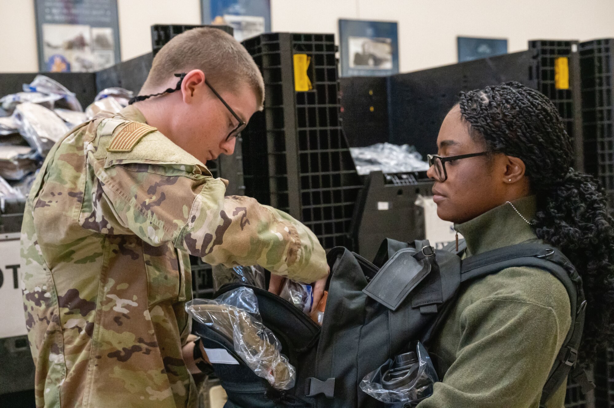 An incoming trainee receives a backpack and supplies for her seven-and-a-half weeks of Basic Military Training on April 23, 2024. Every Tuesday, new recruits are bussed in from the San Antonio International Airport to Joint Base San Antonio-Lackland, Texas, to begin seven-and-a-half weeks of Basic Military Training. The PRC represents the start of their transformation from civilians into Airmen. (U.S. Air Force by Ava Leone)