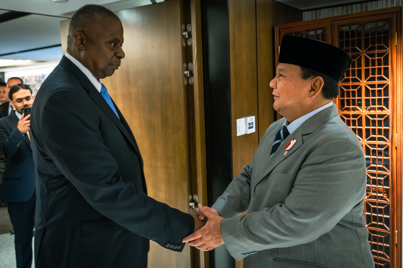 Two people in business attire shake hands.