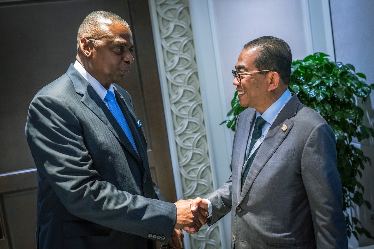 Two people in business attire shake hands.