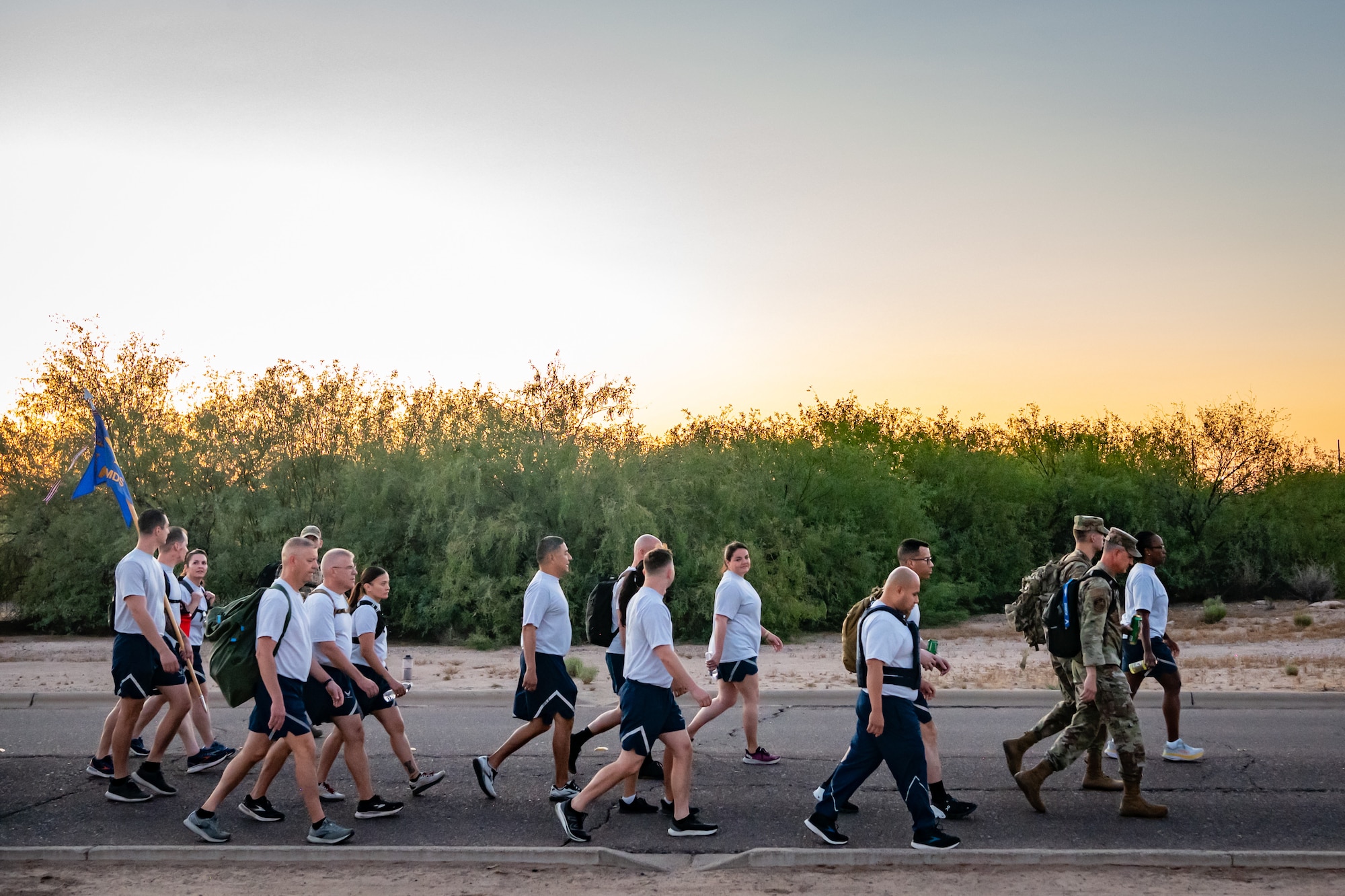 Members of the 944th Fighter Wing honor fallen comrades during a “Fallen Comrade Ruck,” at Luke Air Force Base, Ariz., June 2, 2024. The 944th Top Three organized the event, which saw participants from various squadrons come together, carrying weighted packs or vests for a two-mile trek, starting with a roll call at 5 a.m. Participants also contributed to a food drive, bringing canned goods that were collected at the end of the ruck to be donated to local food banks. This added an element of community service to the commemorative efforts, emphasizing the wing’s commitment to service before self. (U.S. Air Force photo by Tech. Sgt. Tyler J. Bolken)