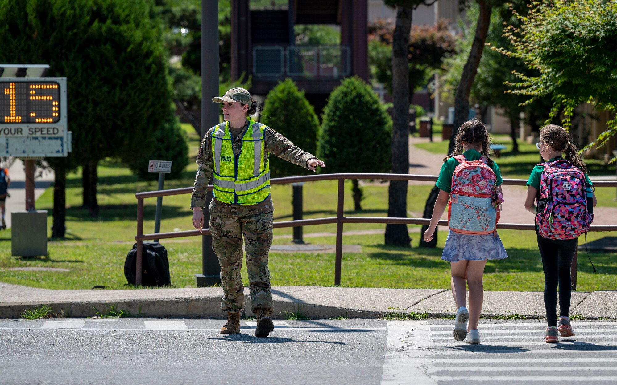 U.S. Air Force Airman 1st Class Gwenyth McCutchen, 51st Security Forces Squadron response force member apprentice, guides children across the street after a student school release at Osan Air Base, Republic of Korea, May 31, 2024. The 51st SFS crossing guards played a vital role in ensuring adherence to safe driving practices, crucial for maintaining smooth traffic flow on roads and safeguarding 51st Fighter Wing Airmen and their family members as they navigated to and from school. (U.S. Air Force photo by Senior Airman Sabrina Fuller-Judd)