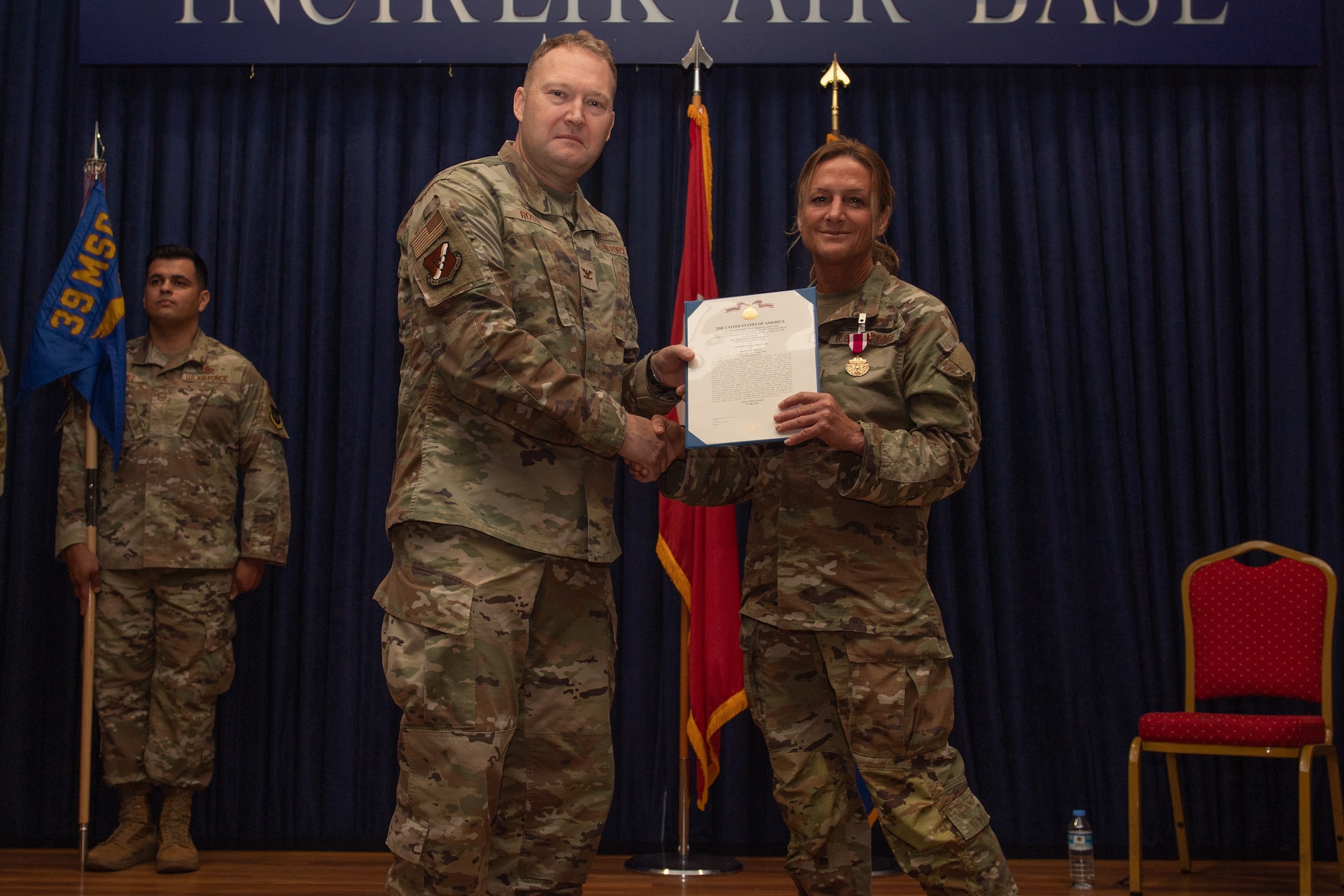 U.S. Air Force Col. Jason Rossi, 39th Mission Support Group commander, presents a decoration to Lt. Col. Angie Cox, 39th Communications Squadron commander, at a change of command ceremony at Incirlik Air Base, Türkiye.
