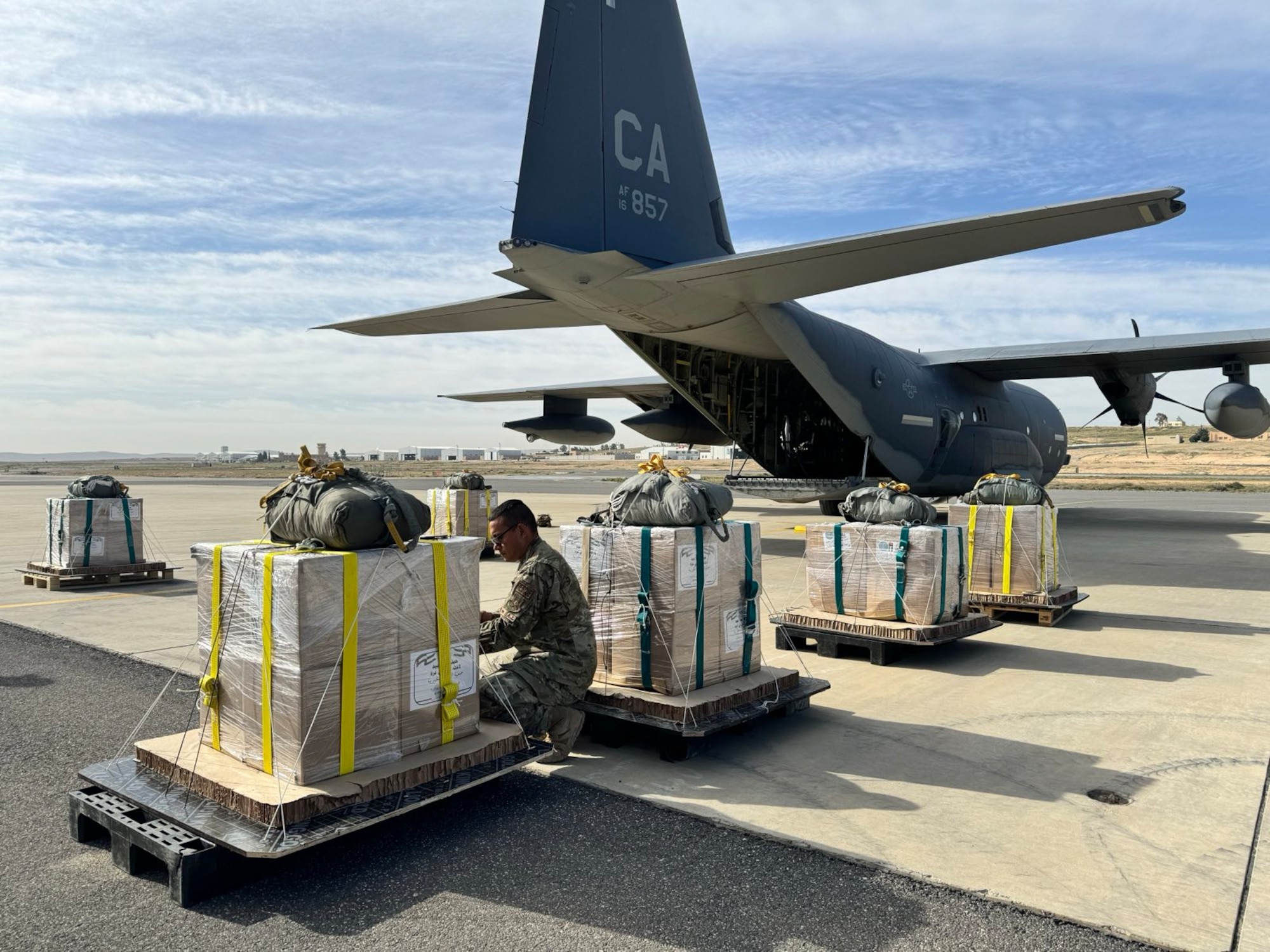 U.S. Air Force loadmasters prepare humanitarian aid for airdrop by a U.S. Air Forces Central HC-130J Combat King II at an undisclosed location in the U.S. Central Command area of responsibility, March 14, 2024. This is the tenth U.S. airdrop since March 2 to support civilian populations on the ground in Gaza. Delivering humanitarian aid through an airdrop ensures the aid is received by civilians most in need without delay for communities that may be difficult to reach on the ground due to geography. (U.S. Air Force photo)