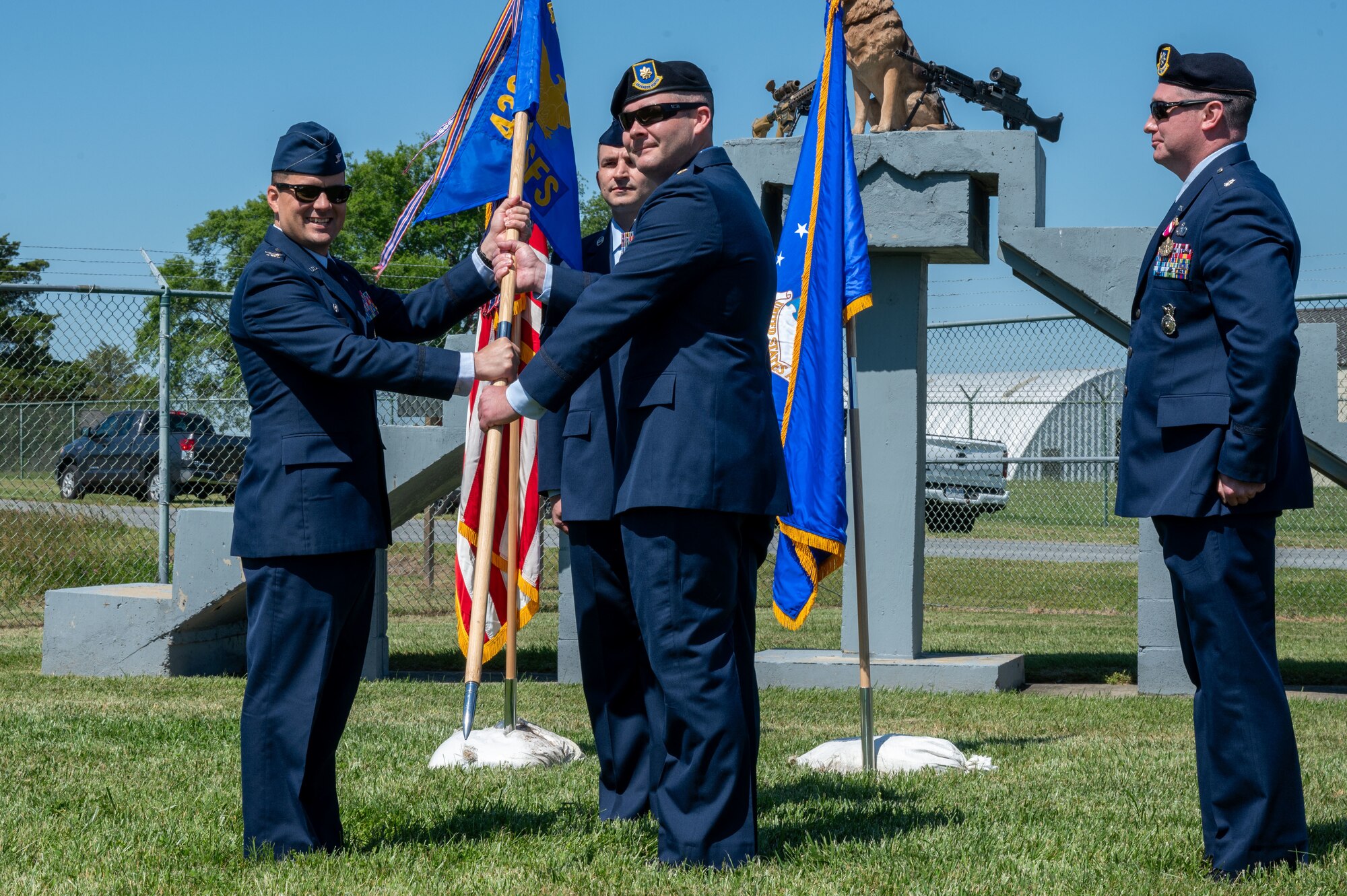 U.S. Air Force Col. Jason Holcomb, 436th Mission Support Group commander, left, passes the guidon to Maj. Daniel Parsons, incoming 436th Security Forces Squadron commander, right, during a change of command ceremony at Dover Air Force Base, Delaware, May 31, 2024. Parsons was previously the executive officer for Director of Logistics, Civil Engineering, Force Protection and Nuclear Integration, Headquarters Air Force Materiel Command. (U.S. Air Force photo by Airman Liberty Matthews)