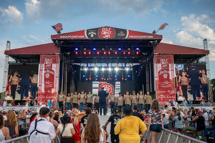 Maj. Gen. Michael A. Valle, Air National Guard Assistant to the Commander for the Continental United States North American Aerospace Defense Command Region (CONR) and First Air Force (Air Forces Northern & Air Forces Space), administers the oath of enlistment to fifteen new Airmen and Guardians during a ceremony at the Gulf Coast Jams County Music Festival held in Frank Brown Park.