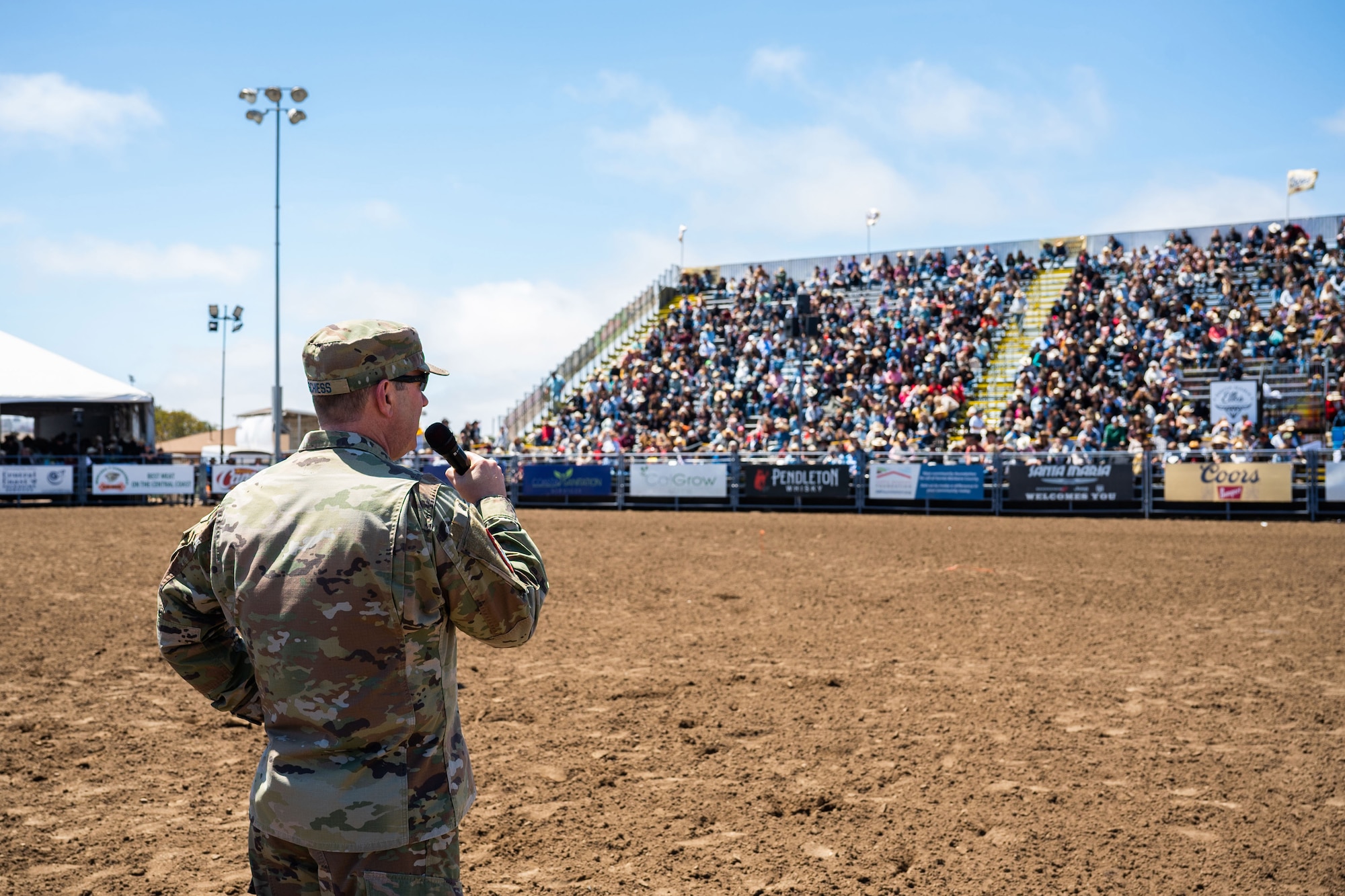 A U.S. Space Force General speaks to a very large crowd at a rodeo.