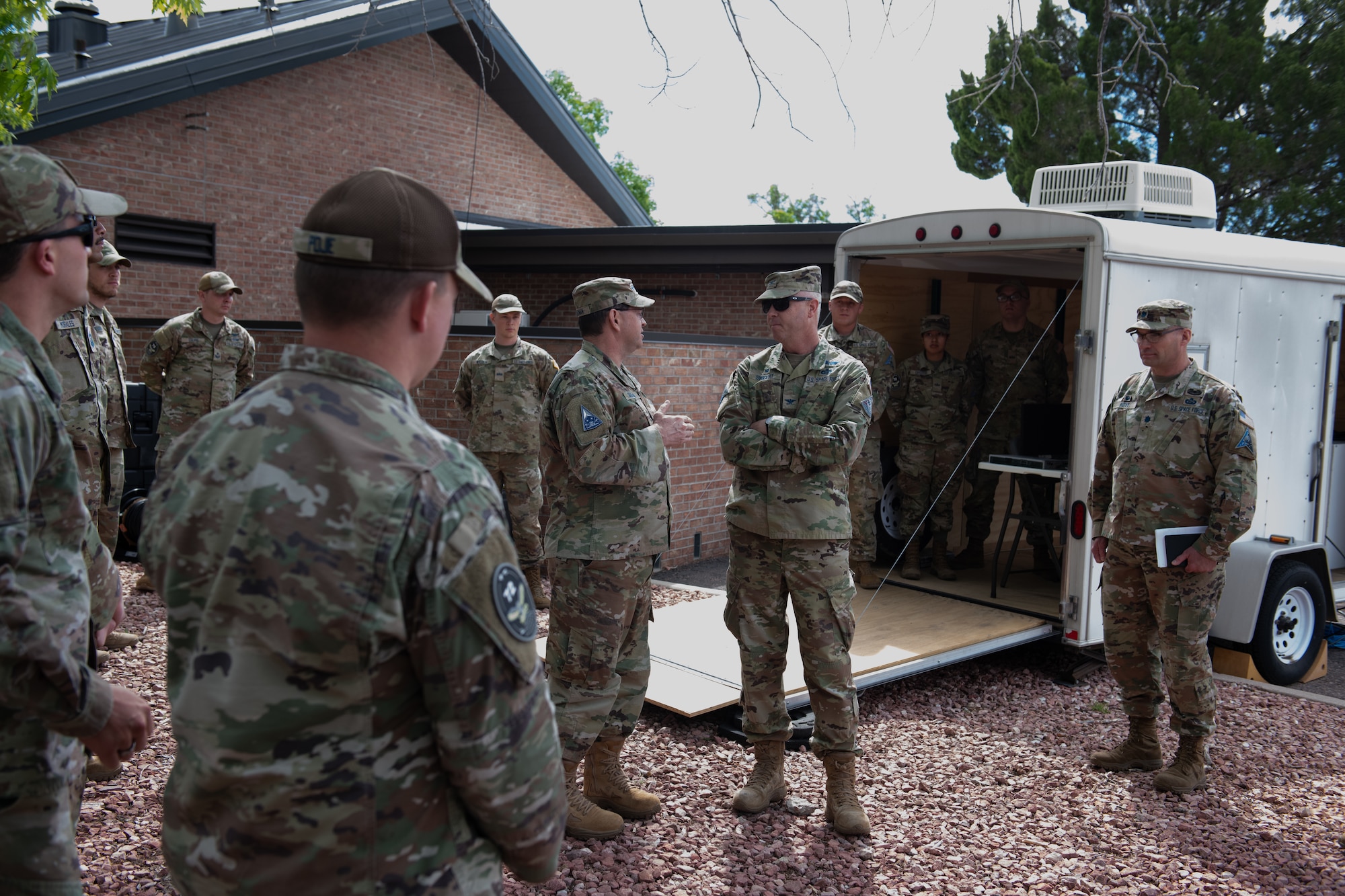 Chief of Space Operations Gen. Chance Saltzman talks with Col. Brett T. Swigert while surrounding Guardians watch and listen.