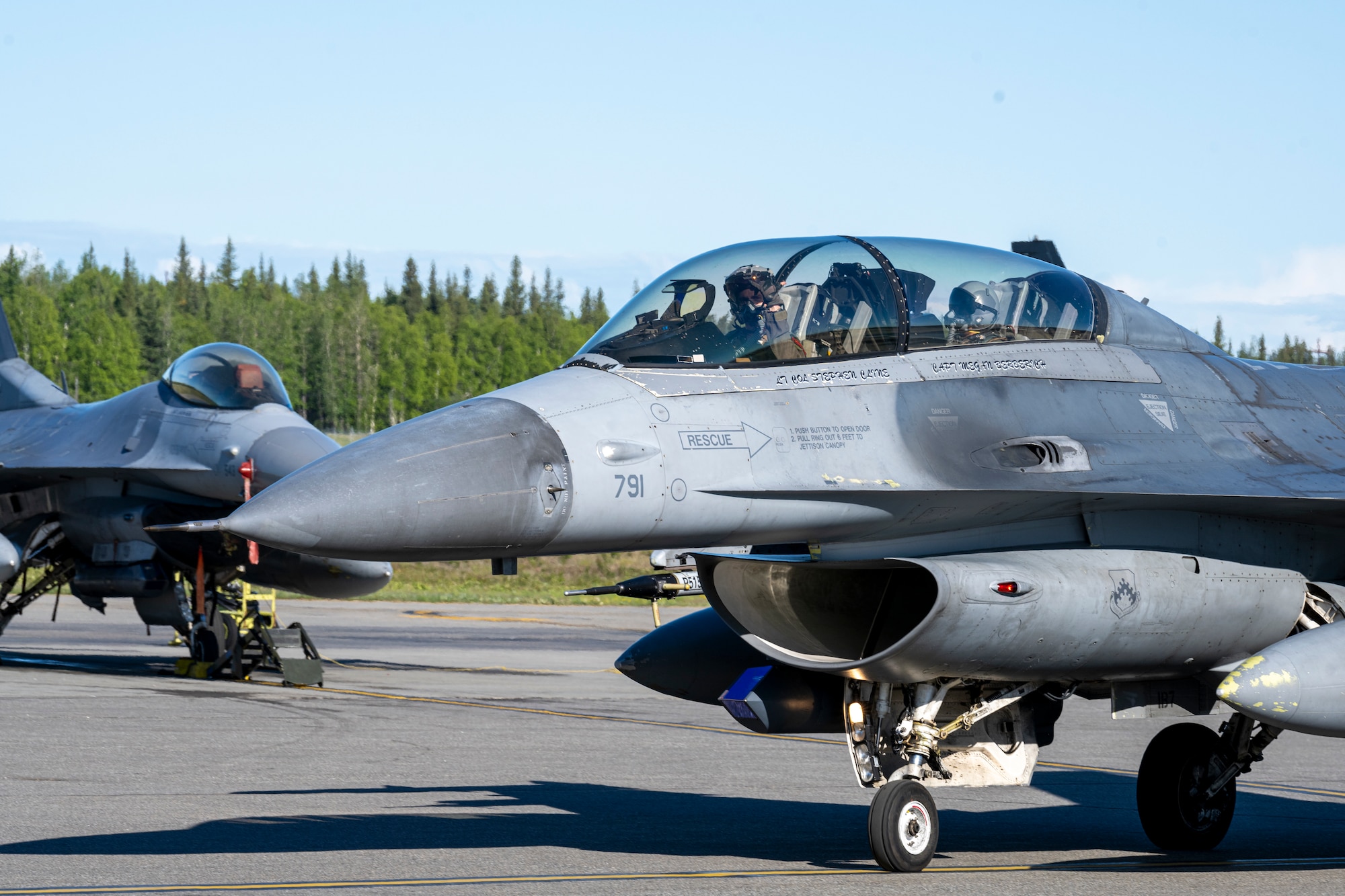 Two F-16 aircraft taxi for take off.