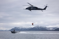 Alaska Air National Guard HH-60G Pave Hawk helicopter aviators assigned to the 210th Rescue Squadron hoist two 212th Rescue Squadron pararescuemen during underway hoist training in the Prince William Sound near Whittier, Alaska, May 16, 2024. The Airmen of the 212th RQS are trained, equipped, and postured to conduct full-spectrum personnel recovery to include both conventional and unconventional rescue operations. The 212th, along with the 210th and 211th RQSs, make up the 176th Wing Rescue Triad and are among the busiest combat search and rescue units in the world. (Alaska National Guard photo by Alejandro Peña)