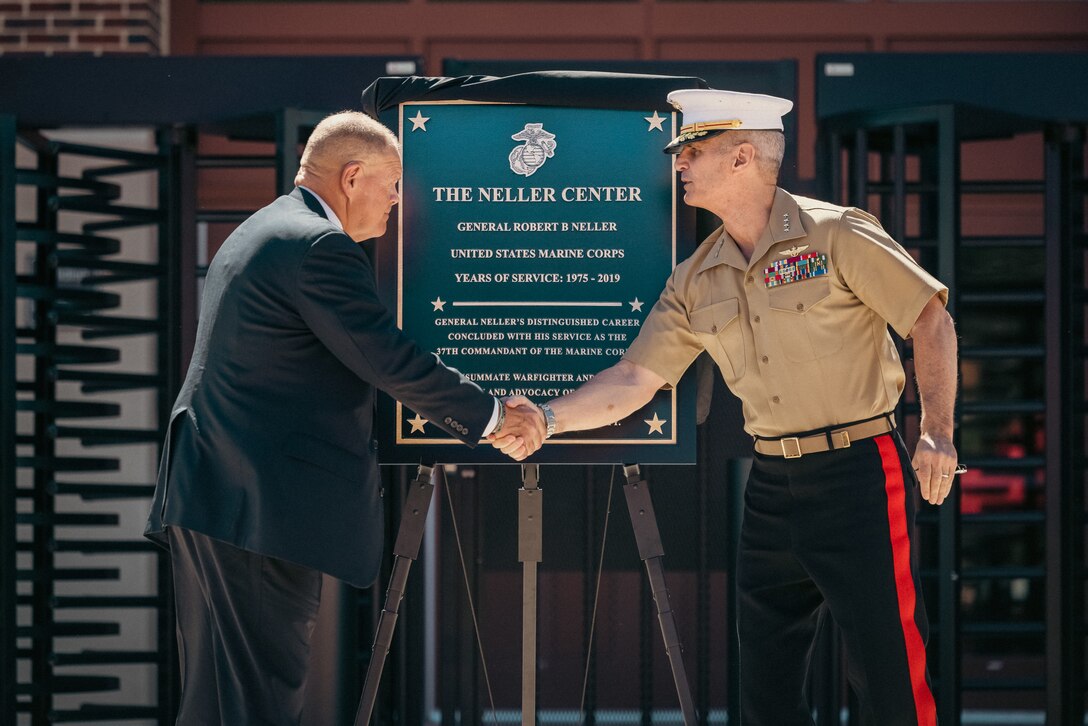 U.S. Marine Corps Retired Gen. Robert Neller, the 37th commandant of the Marine Corps, and Gen. Christopher Mahoney, the assistant commandant of the Marine Corps, shake hands during the dedication ceremony for the General Robert B. Neller Center for Wargaming and Analysis on Marine Corps Base Quantico, May 31, 2024. The new building will be a center for Marines to wargame in a secure, centralized, location to enhance the Marine Corps’ ability to make analytically informed decisions. (U.S. Marine Corps photo by Lance Cpl. Ethan Miller)