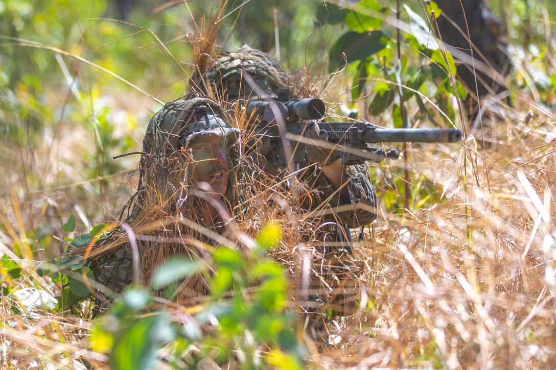 U.S. Marine Corps Cpl. Declan Teague, left, a point man, and Lance Cpl. Andrew Manson, an assistant radio operator, both with Weapons Company, 2nd Battalion, 5th Marine Regiment (Reinforced), Marine Rotational Force – Darwin 24.3, search for their target during a live-fire stalking exercise at Mount Bundey Training Area, NT, Australia, May 22, 2024. Marines and Sailors worked alongside their Australian Army counterparts to deliver long-range precision fires on selected targets from concealed positions. Teague is a native of Idaho. Manson is a native of North Dakota. (U.S. Marine Corps photo by Cpl. Migel A. Reynosa)
