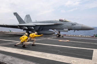 Lt. Brandon White, left, and Lt. Charles Fitzmaurice launch an F/A-18E from VFA-115 during flight operations aboard USS Ronald Reagan (CVN 76) in the Philippine Sea.