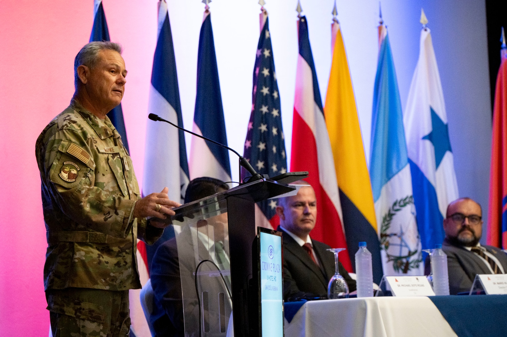 A photo of a man standing at a podium speaking.