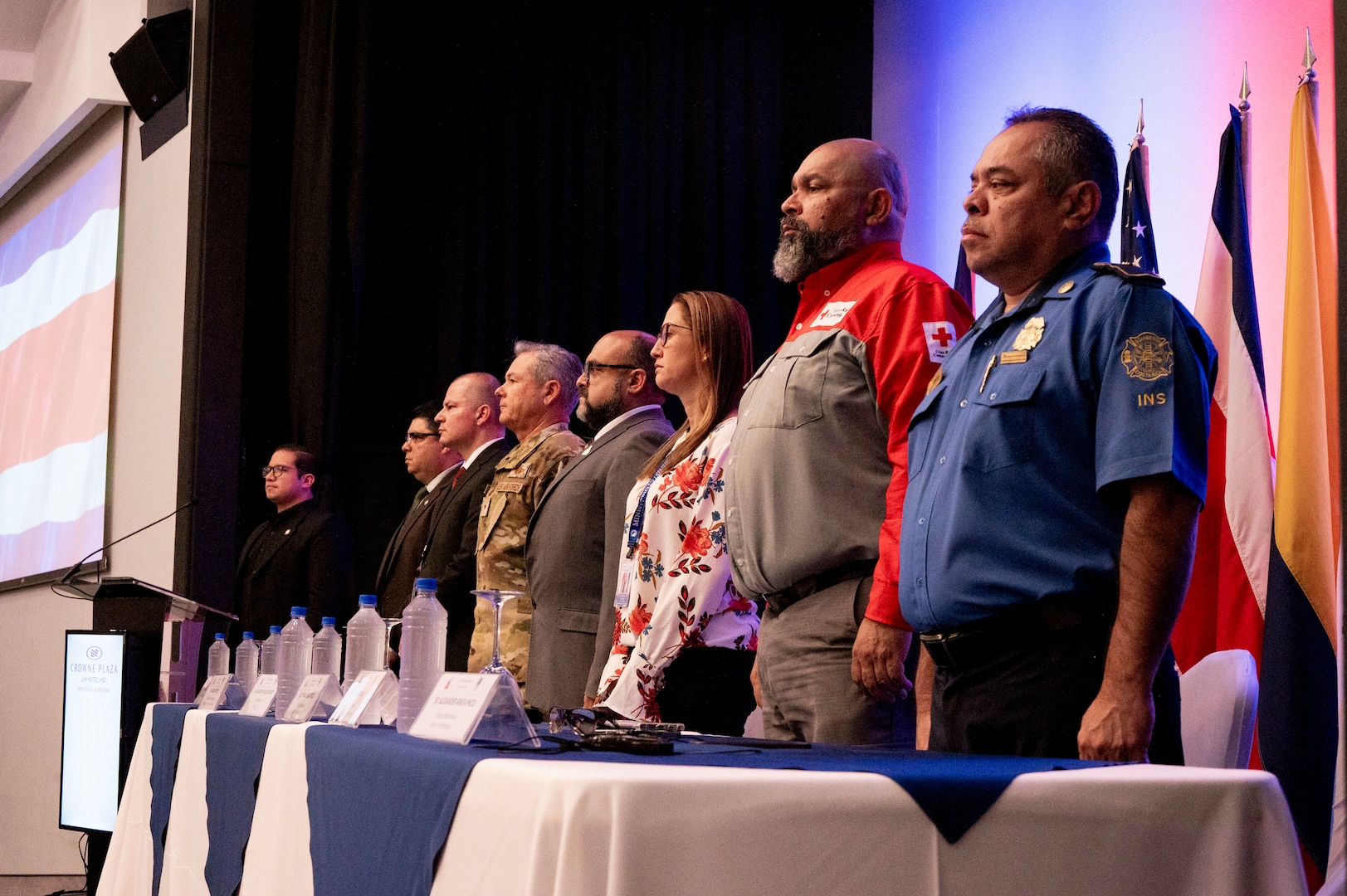 A photo of people standing on stage at a table.