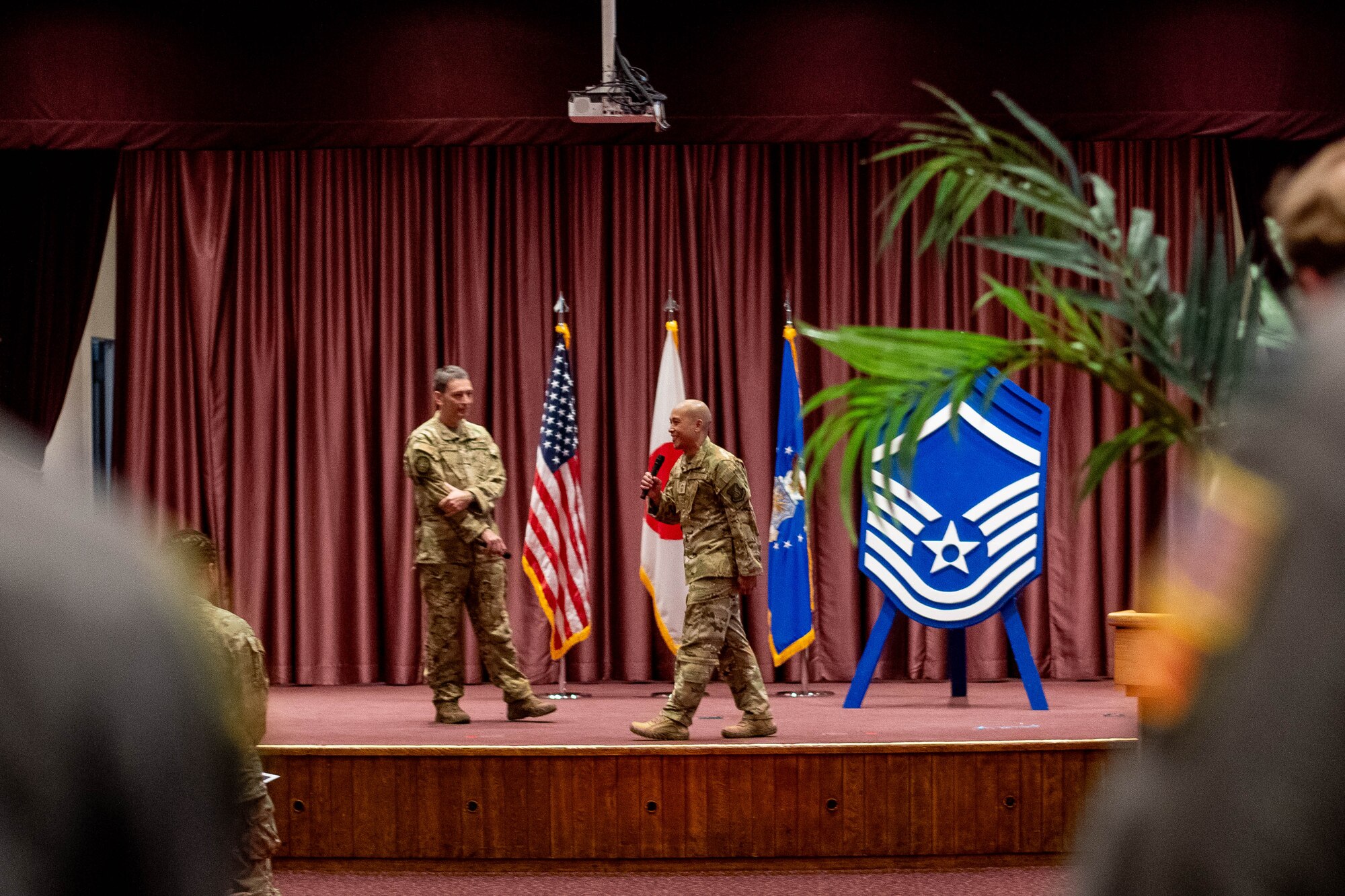 U.S. Air Force Col. Andrew Roddan, 374th Airlift Wing commander, left, and Chief Master Sgt. Kristofer Reyes, 374th Operations Group command chief, right, give remarks.