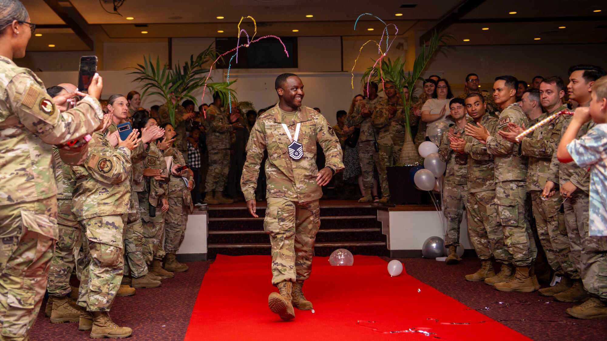 U.S. Air Force Tech. Sgt. Quintez Henry, 374th Force Support Squadron post master, walks to accept a plaque.