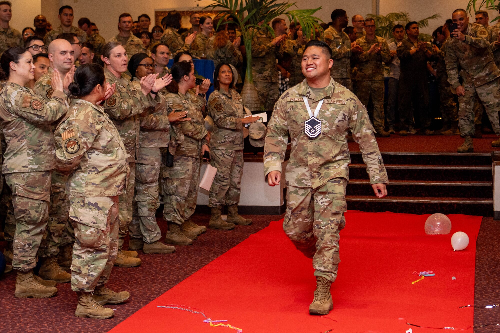 U.S. Air Force Tech. Sgt. Angelo Patungan, 374th Logistics Readiness Squadron NCO in charge of travel management office outbound cargo, walks to accept a plaque.