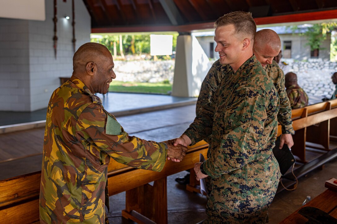 U.S. Navy Petty Officer 1st Class Nicholas Kless, right, a religious program specialist with Marine Rotational Force – Darwin 24.3, shakes the hand of a Papua New Guinea Defence Force member during a humanitarian assistance and disaster relief exercise at Murray Barracks, Port Moresby, Papua New Guinea, May 1, 2024. During the HADR exercise, MRF-D 24.3 is working in coordination with the Papua New Guinea Defence Force and U.S. Embassy in Port Moresby, with a focus on projecting select role II medical, logistics, and Marine Air-Ground Task Force command and control capabilities off-continent, to validate HADR training and readiness. Kless is a native of Texas. (U.S. Marine Corps photo by Cpl. Juan Torres)