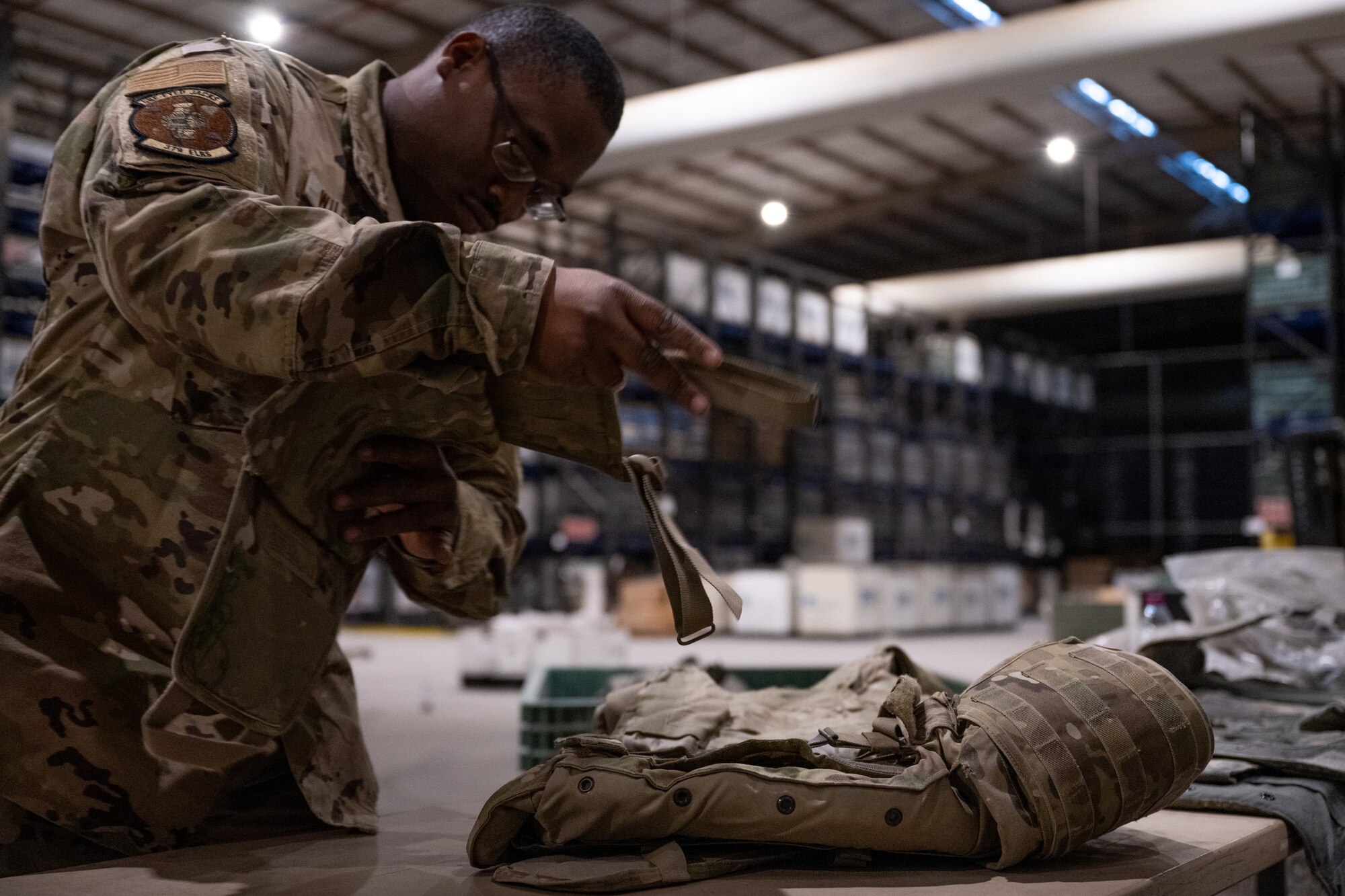 An Airman assigned to the 379th Expeditionary Logistics Readiness Squadron inspects a piece of a plate carrier at an undisclosed location in the U.S. Central Command area of responsibility, May 31, 2024.