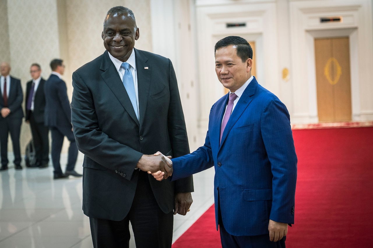 Two people in business attire shake hands.