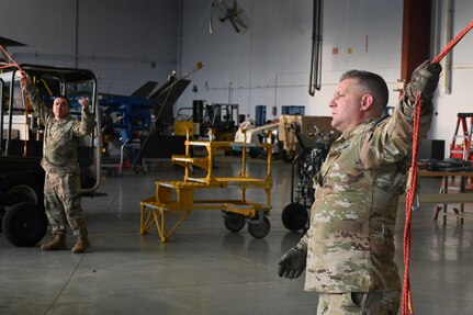 A member of the District of Columbia National Guard's Army Aviation Facility tows a UH-60 Black Hawk helicopter at Davison Army Airfield, May 21, 2024. D.C. Army National Guard Aviation organized an all-female flight crew to commemorate the first woman to graduate Army flight school and the first female officer to achieve pilot status in June 1974.