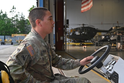 A member of the District of Columbia National Guard's Army Aviation Facility tows a UH-60 Black Hawk helicopter at Davison Army Airfield, May 21, 2024. D.C. Army National Guard Aviation organized an all-female flight crew to commemorate the first woman to graduate Army flight school and the first female officer to achieve pilot status in June 1974.