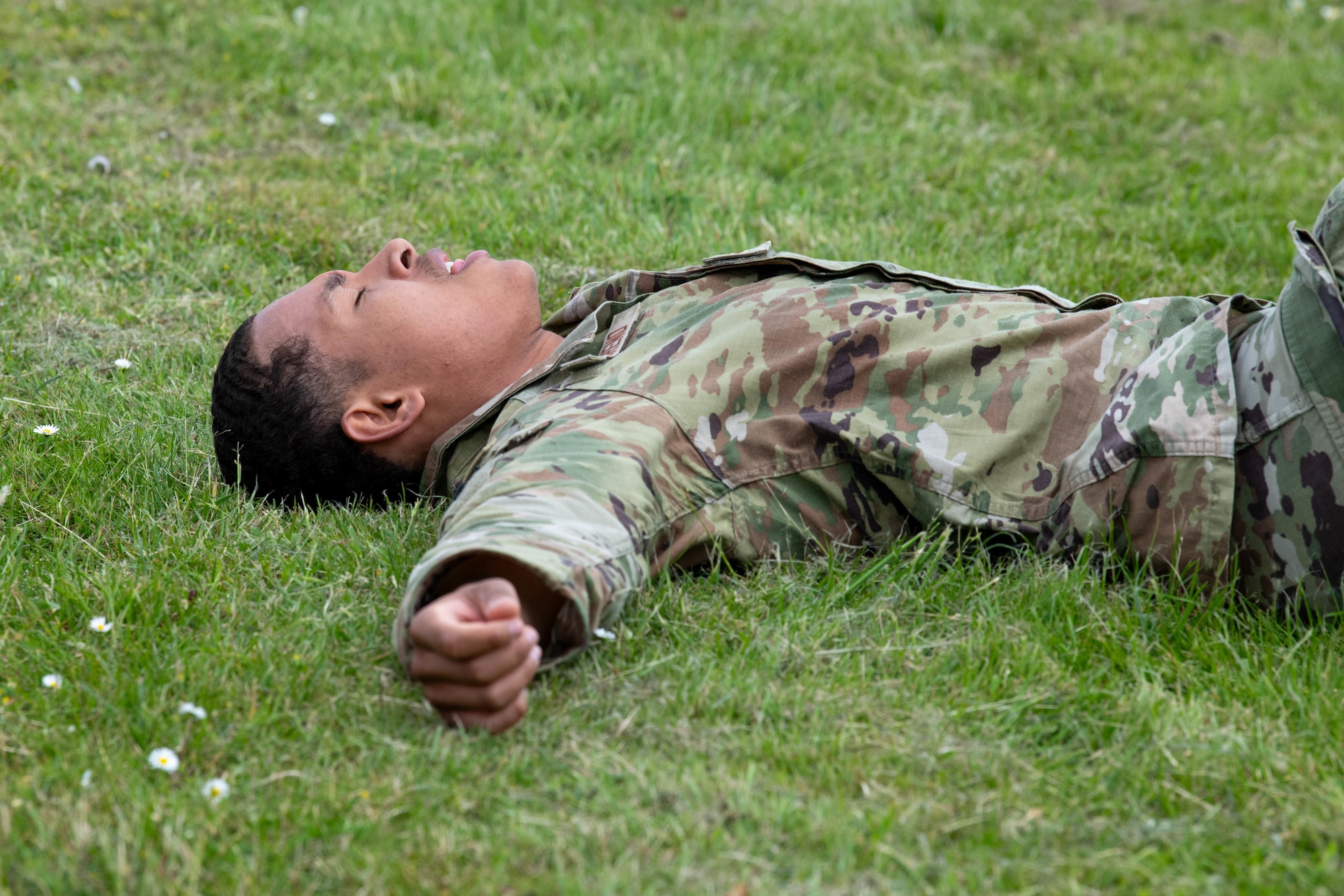 A competitor recovers in the grass after a Norwegian Foot March