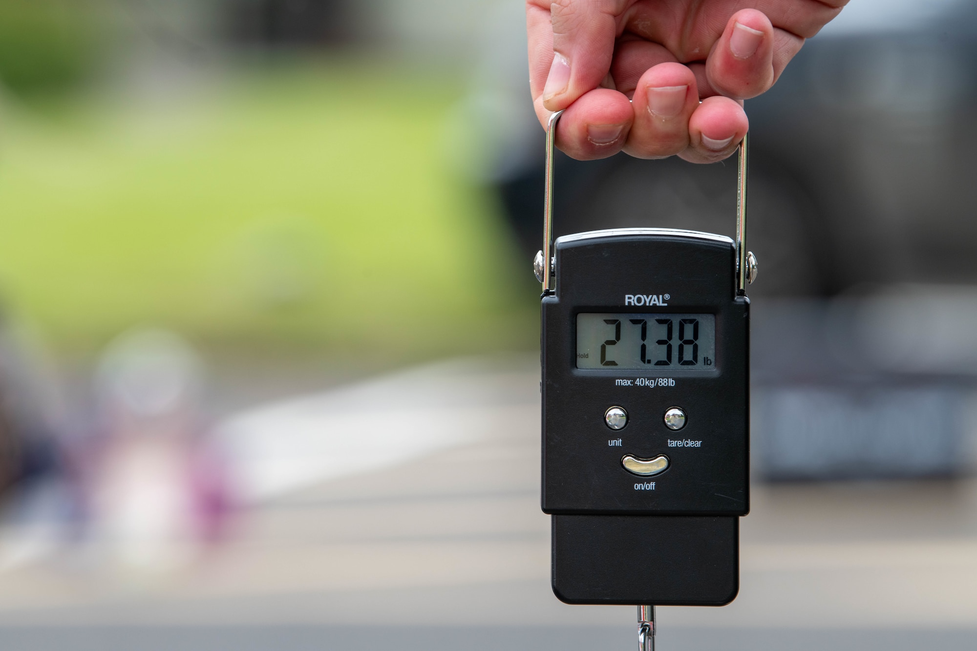 A scale weighs a rucksack at 27.38 lbs