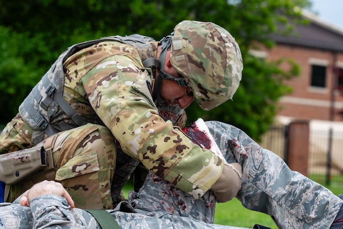 Airman assists simulated patient.