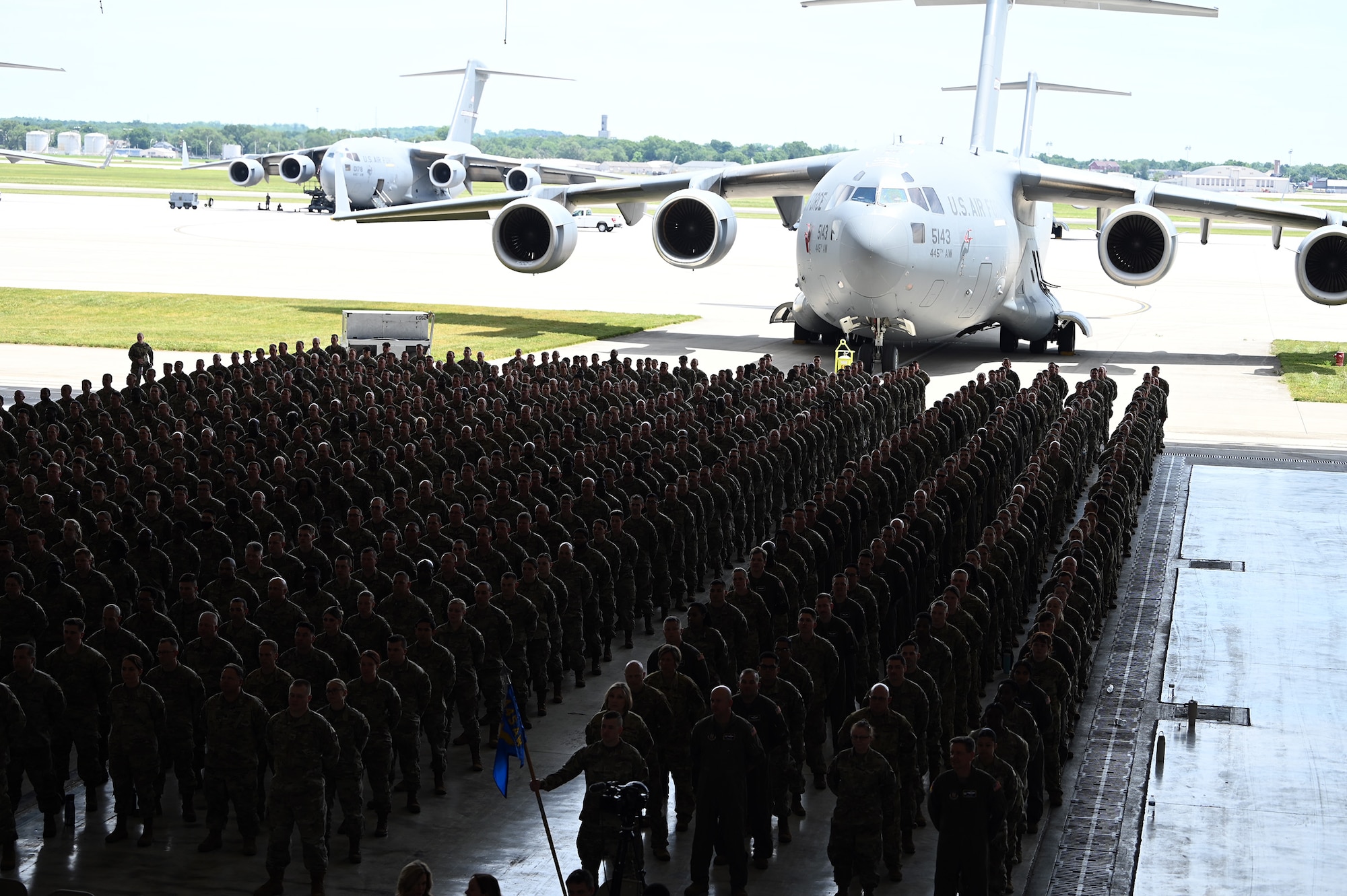 445th Airlift Wing Reserve Citizen Airmen stand in formation during as the C-17 Globemaster III provides the perfect backdrop during the 445th Airlift Wing Assumption of Command Ceremony held at Wright-Patterson Air Force Base, Ohio June 1, 2024. Col. Douglas Perry, Jr., assumed command of the wing after serving as the commander of the 434th Operations Group, Grissom Air Reserve Base, Indiana. (U.S. Air Force photo/Master Sgt. Patrick O’Reilly)