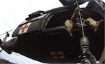 Tennessee Army National Guard Black Hawk helicopter crew chief Sgt. Daniel Bandy hoists Sgt. 1st Class Giovanni DeZuani, flight paramedic, into the aircraft after rescuing a hiker in respiratory distress in the Great Smoky Mountain National Park at Mount LeConte Lodge May 31, 2024.