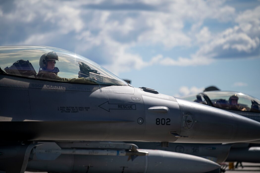 A pilot sit in a jet conducting pre-flight checks